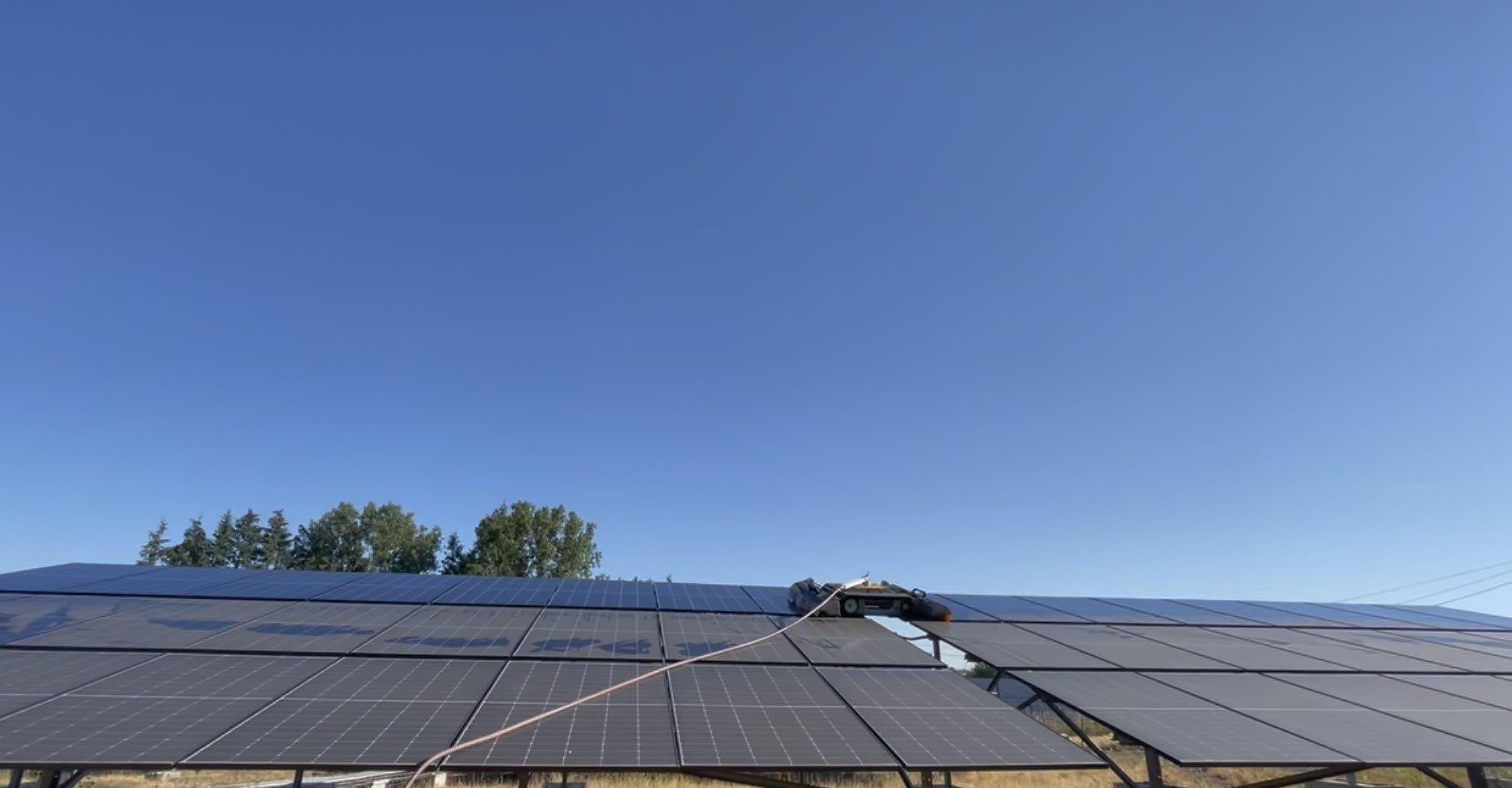 Robot Ellipsys en train de nettoyer une table de modules d'une centrale photovoltaïque au sol